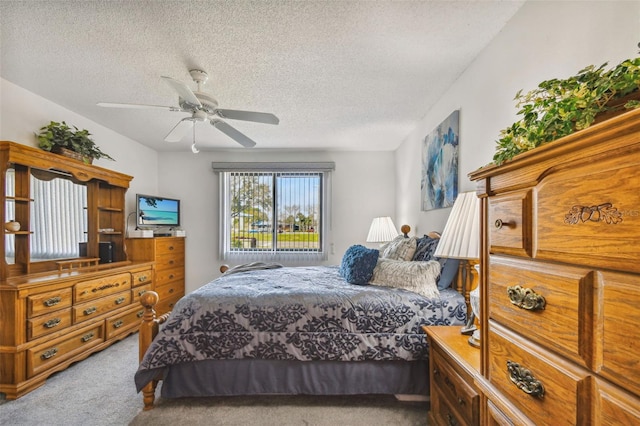 carpeted bedroom with ceiling fan and a textured ceiling