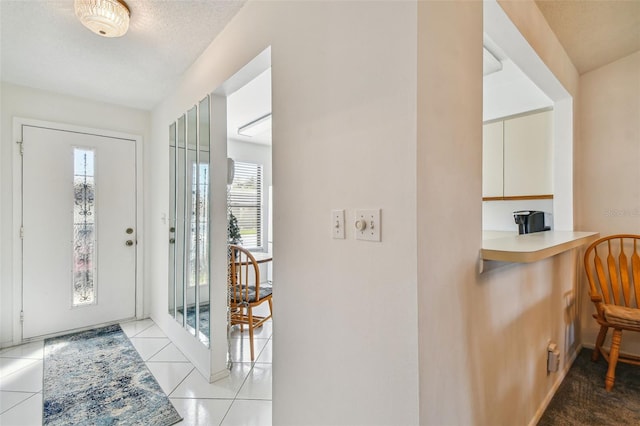 tiled entryway with a textured ceiling and plenty of natural light