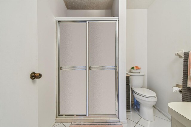 bathroom featuring a textured ceiling, walk in shower, toilet, and tile patterned flooring