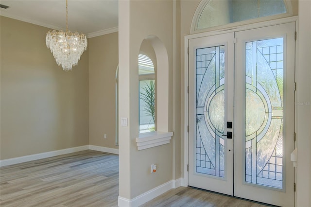 entrance foyer featuring french doors, light hardwood / wood-style floors, and a chandelier