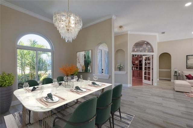 dining area with crown molding, light hardwood / wood-style flooring, and an inviting chandelier