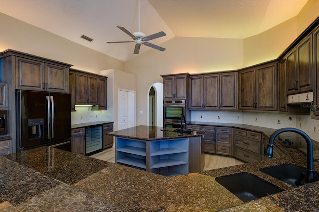 kitchen with high vaulted ceiling, light hardwood / wood-style floors, stainless steel appliances, ceiling fan, and sink