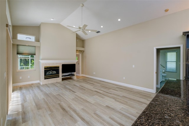 unfurnished living room featuring high vaulted ceiling, ceiling fan, and light hardwood / wood-style flooring