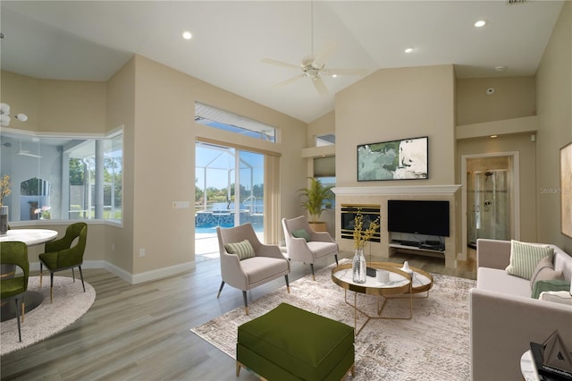 living room featuring high vaulted ceiling, ceiling fan, and light hardwood / wood-style flooring