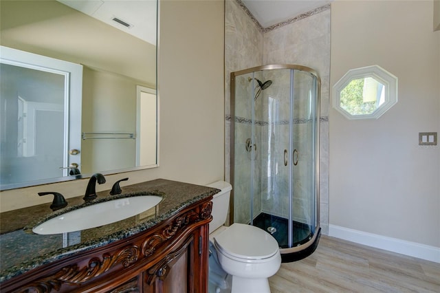 bathroom featuring walk in shower, oversized vanity, toilet, and wood-type flooring