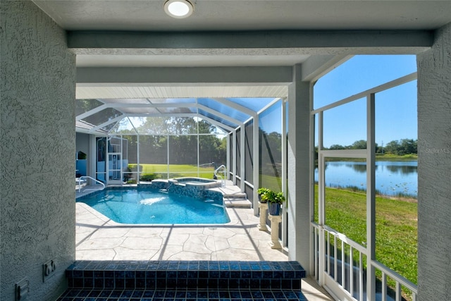 view of swimming pool featuring a patio, glass enclosure, a lawn, a water view, and an in ground hot tub