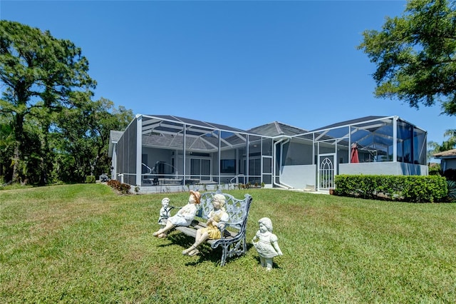 rear view of house featuring a lawn and a lanai