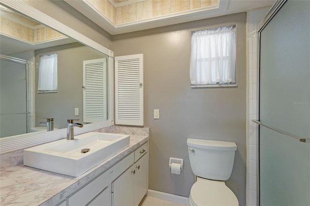 bathroom featuring toilet, vanity, and a shower with door