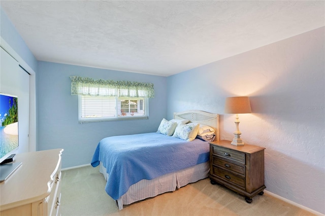 carpeted bedroom with a textured ceiling and a closet