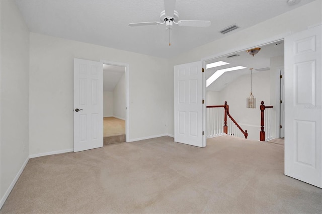 carpeted spare room featuring ceiling fan and vaulted ceiling