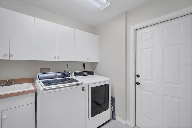 washroom featuring hookup for an electric dryer, sink, light tile floors, cabinets, and washing machine and dryer