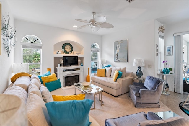 tiled living room featuring a ceiling fan, a high end fireplace, and recessed lighting