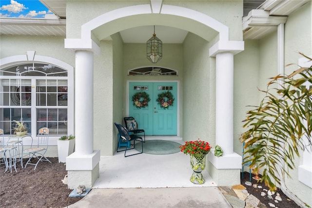 property entrance featuring a porch and stucco siding