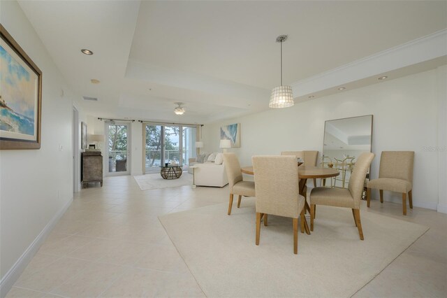 tiled dining room with a tray ceiling