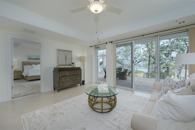 living room with light tile patterned floors, crown molding, a raised ceiling, and ceiling fan