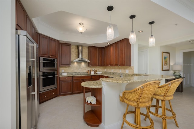 kitchen featuring kitchen peninsula, a breakfast bar area, black electric stovetop, stainless steel fridge with ice dispenser, and wall chimney range hood