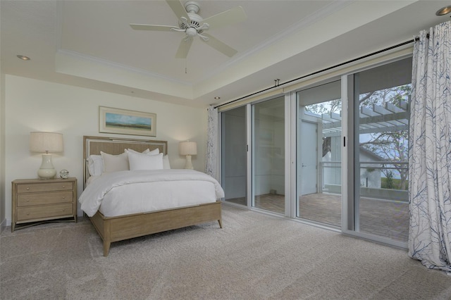 carpeted bedroom featuring crown molding, a tray ceiling, access to outside, and ceiling fan