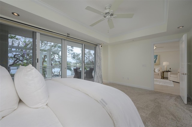 carpeted bedroom with crown molding, ceiling fan, a tray ceiling, and access to outside