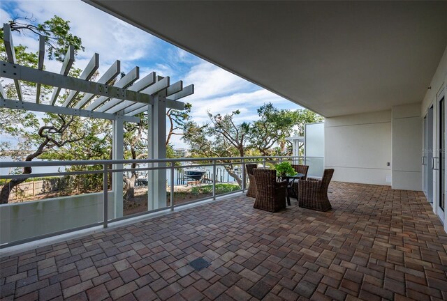 view of patio / terrace with a balcony, a water view, and a pergola