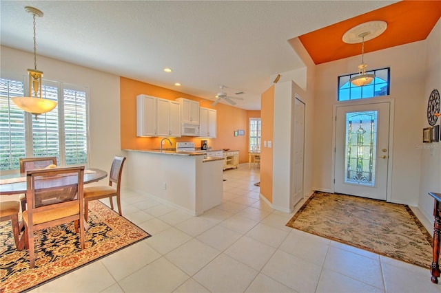 foyer featuring sink, ceiling fan, and light tile flooring