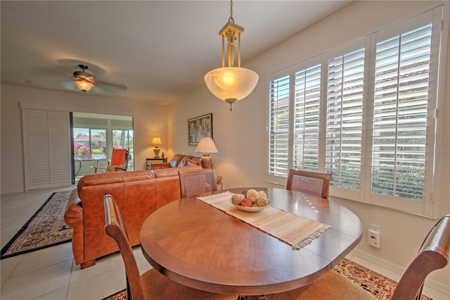 tiled dining space with ceiling fan and a wealth of natural light