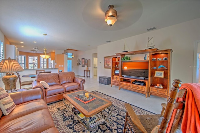 tiled living room with ceiling fan