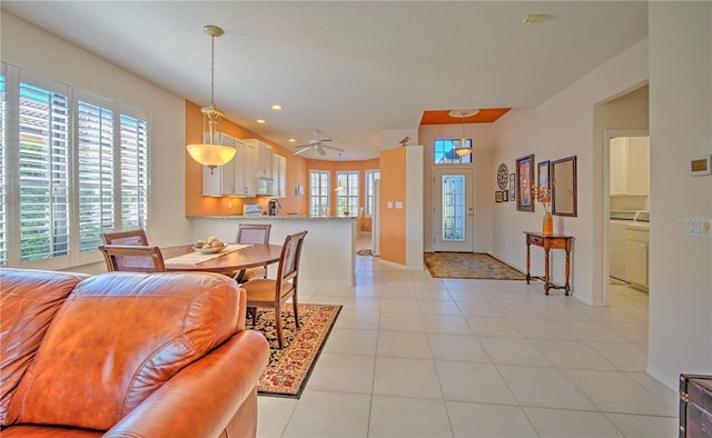 tiled living room featuring washer and dryer and ceiling fan