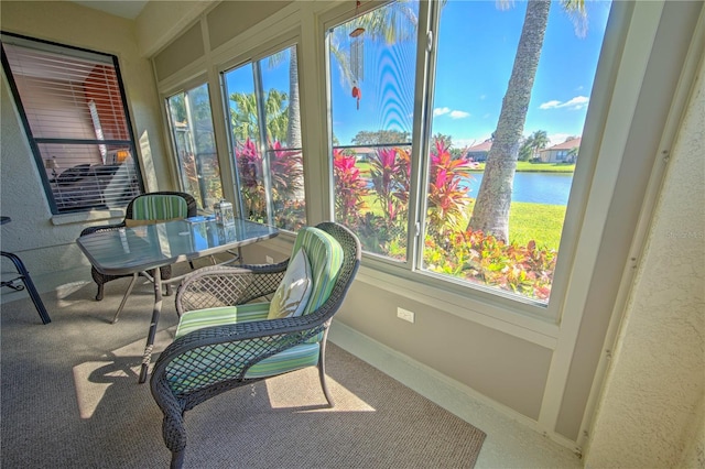 sunroom featuring a water view