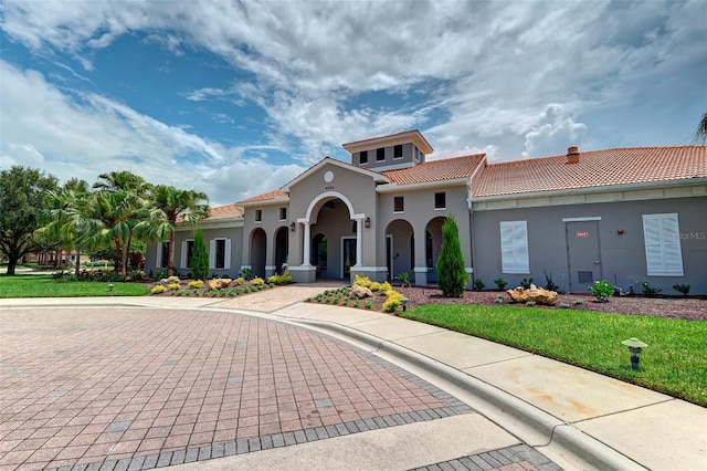 mediterranean / spanish-style house with a front yard