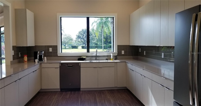 kitchen with dark hardwood / wood-style floors, white cabinets, dishwasher, backsplash, and stainless steel refrigerator