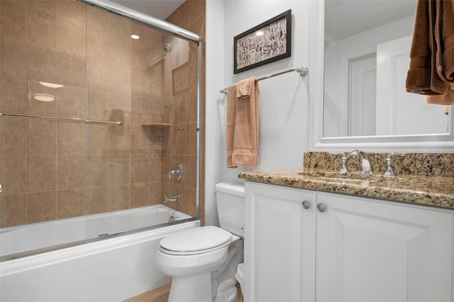 full bathroom featuring vanity, shower / bath combination with glass door, and toilet