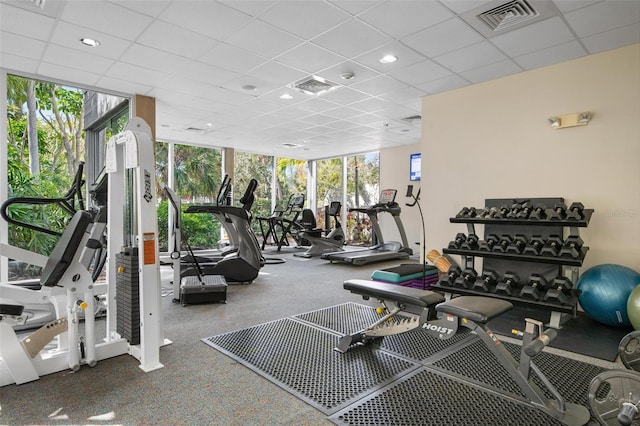 gym with plenty of natural light, floor to ceiling windows, and a paneled ceiling