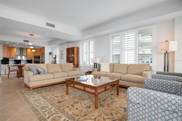 tiled living room featuring crown molding and a tray ceiling