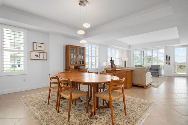 tiled dining area with plenty of natural light and a tray ceiling