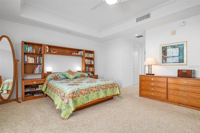 bedroom with crown molding, light carpet, and a tray ceiling