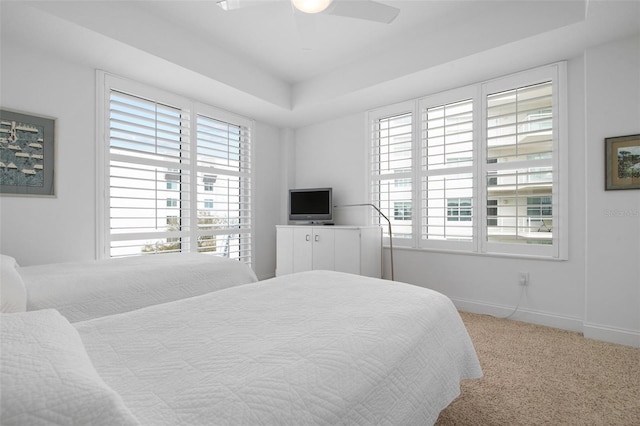 bedroom featuring a tray ceiling, ceiling fan, and carpet flooring