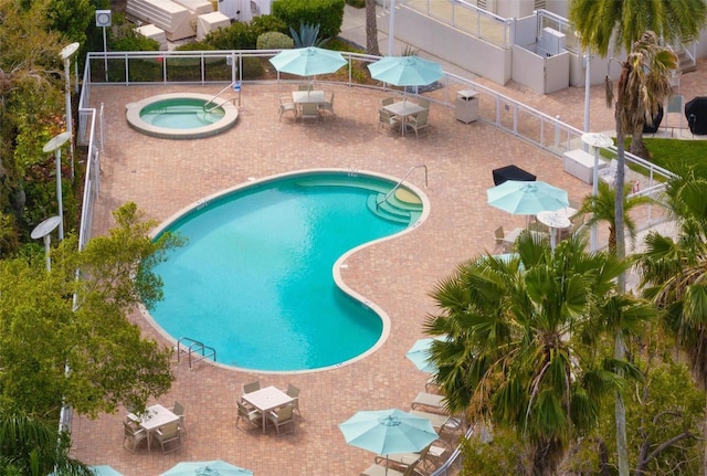 view of swimming pool featuring a community hot tub and a patio area