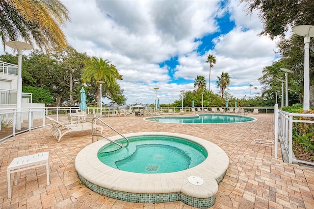 view of pool featuring a patio and a community hot tub