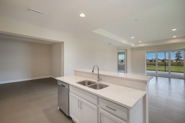 kitchen featuring white cabinetry, a kitchen island with sink, sink, light tile floors, and dishwasher