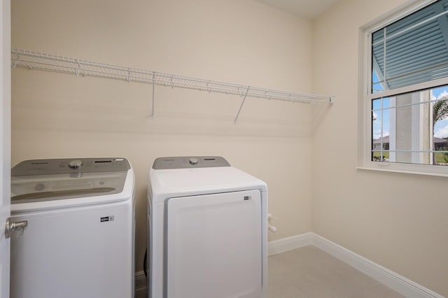 laundry area featuring light tile floors and separate washer and dryer