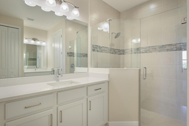 bathroom featuring vanity and a shower with shower door