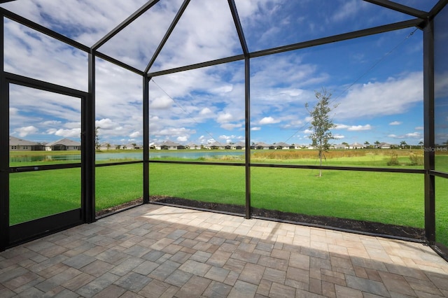 unfurnished sunroom featuring a water view