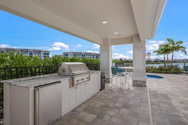 view of terrace with grilling area and an outdoor kitchen