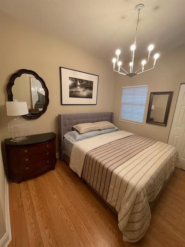 bedroom featuring a chandelier and light wood-type flooring