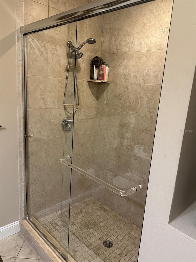 bathroom with a shower with door and tile flooring