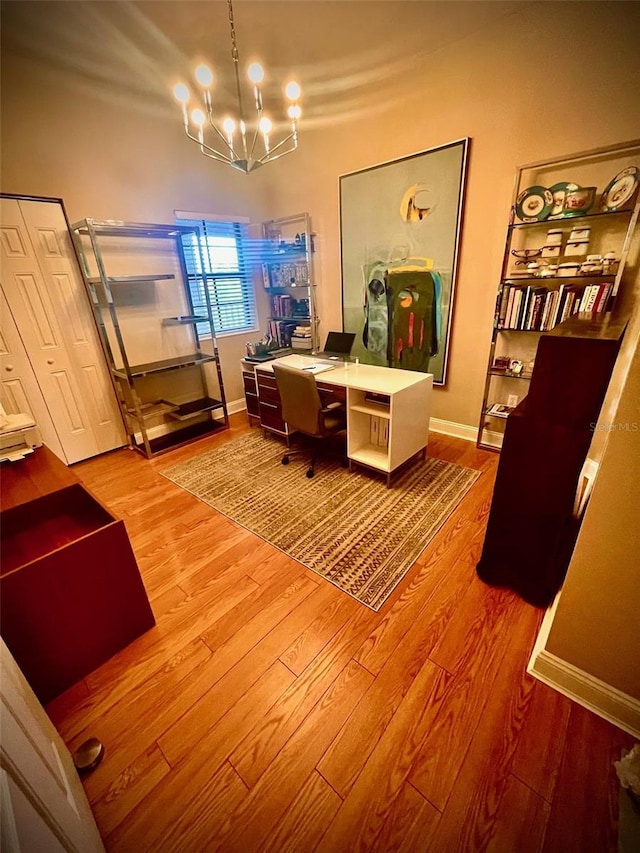 office space with wood finished floors, an inviting chandelier, and baseboards