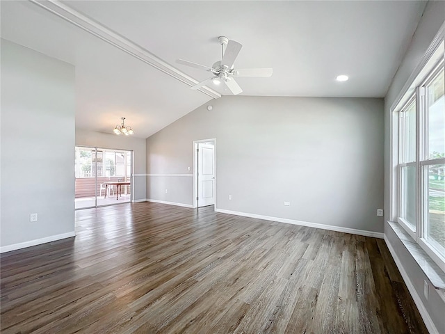 empty room with lofted ceiling, ceiling fan with notable chandelier, and dark hardwood / wood-style flooring