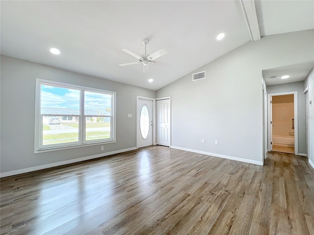 spare room featuring ceiling fan, vaulted ceiling with beams, and light hardwood / wood-style flooring