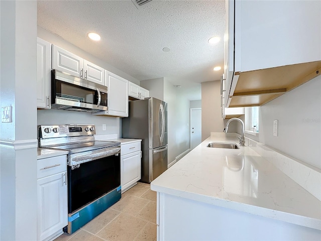 kitchen with light tile flooring, appliances with stainless steel finishes, sink, white cabinets, and light stone counters