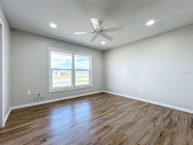 empty room with ceiling fan, a textured ceiling, and hardwood / wood-style flooring